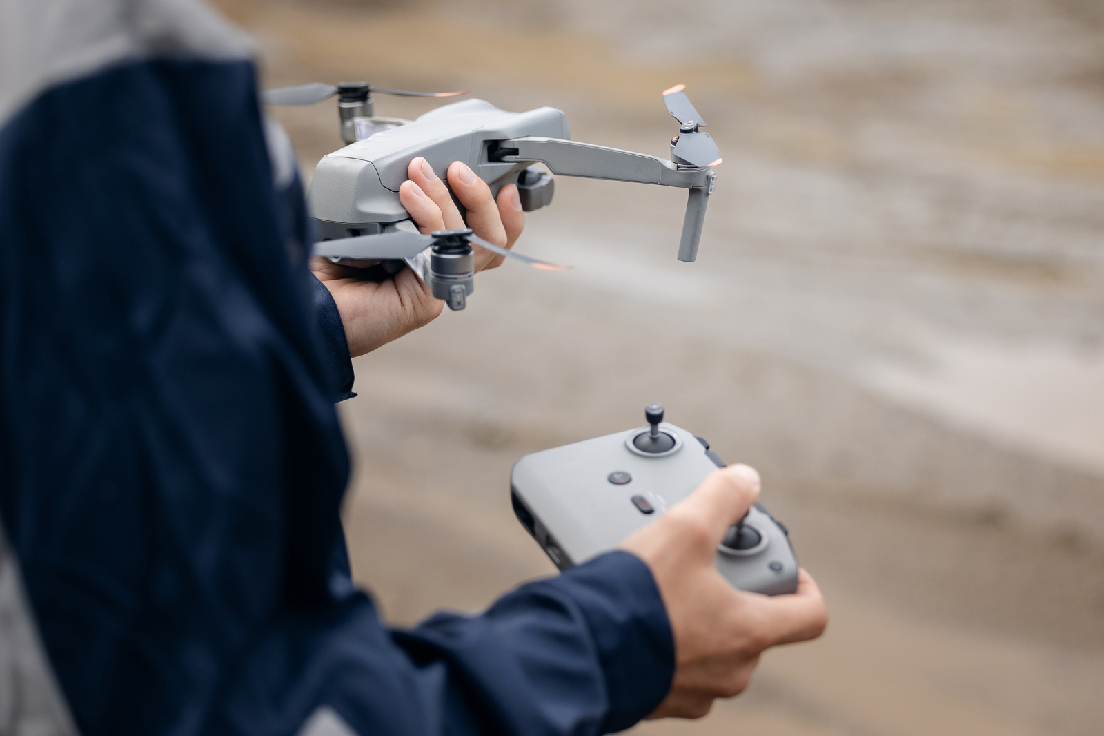 Bestuurder houdt een lichte drone en controller vast, ideaal voor beginners die zonder vliegbewijs willen vliegen.
