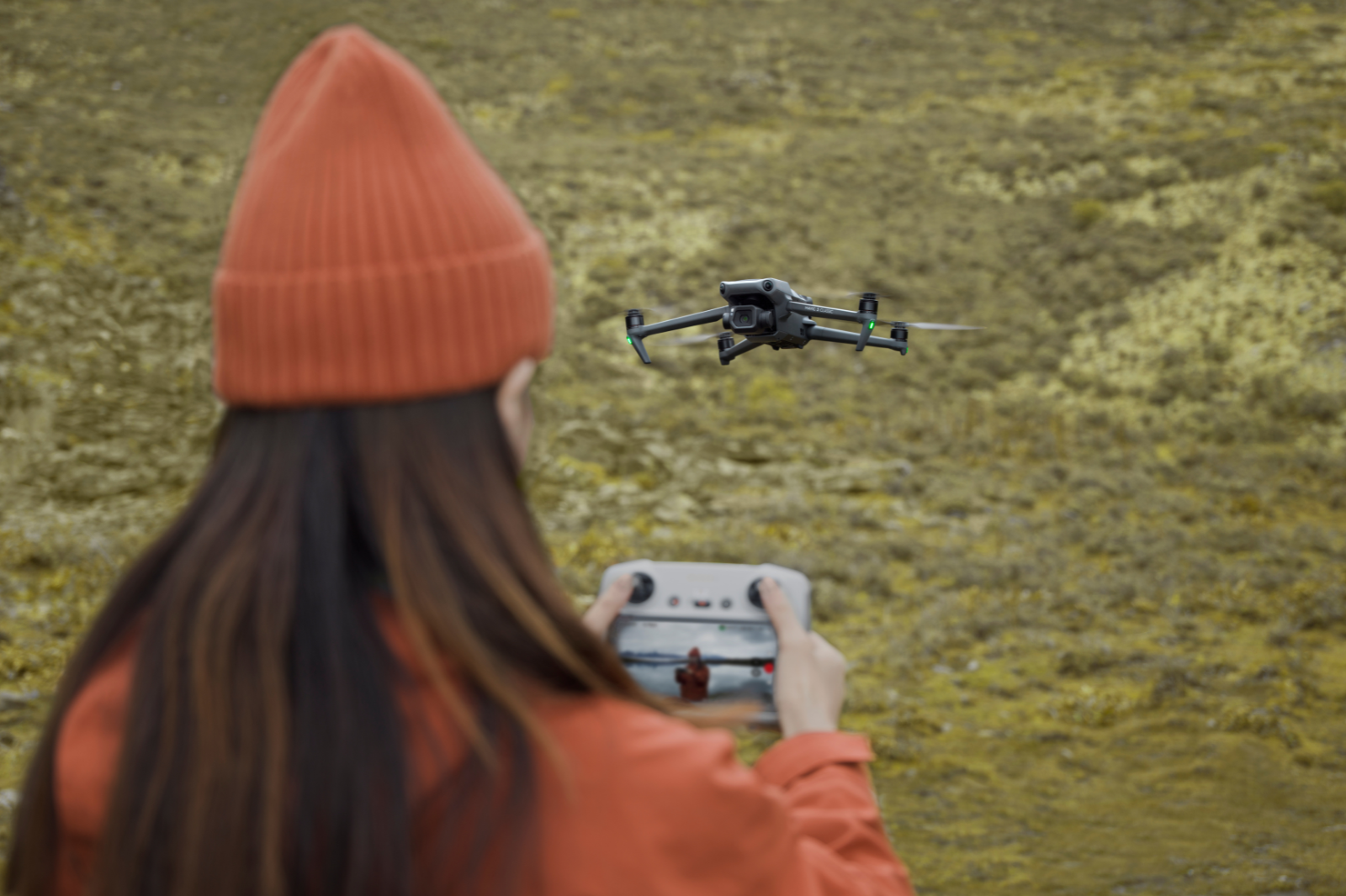 Vrouw oefent drone vliegen in de natuur met DJI controller