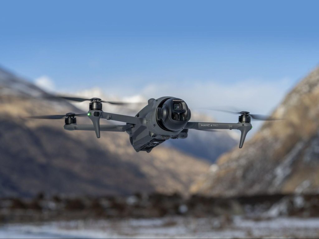 Professionele cameradrone vliegt boven een besneeuwd berglandschap.
