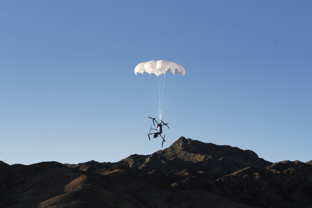 DJI AP100 parachute ontplooit tijdens een testvlucht boven bergachtig terrein
